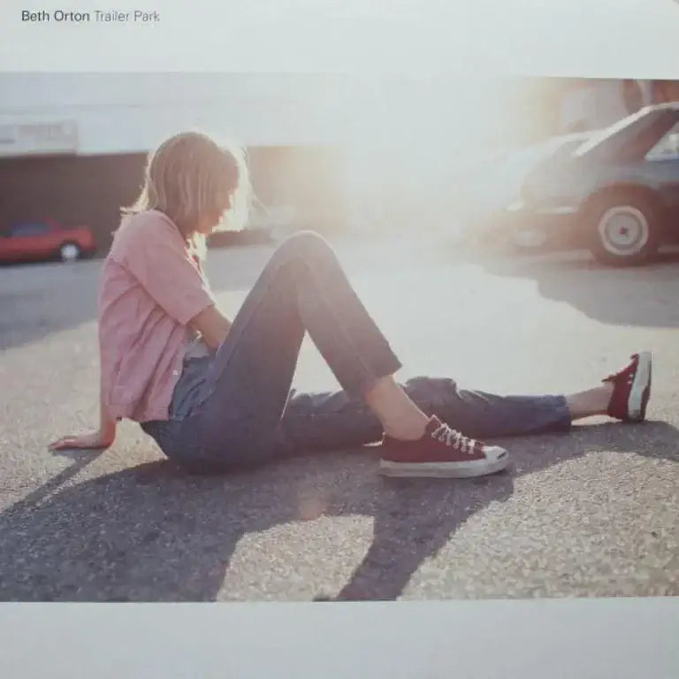 Beth Orton Trailer Park album cover featuring artist sitting on pavement in sunlight, vintage aesthetic.